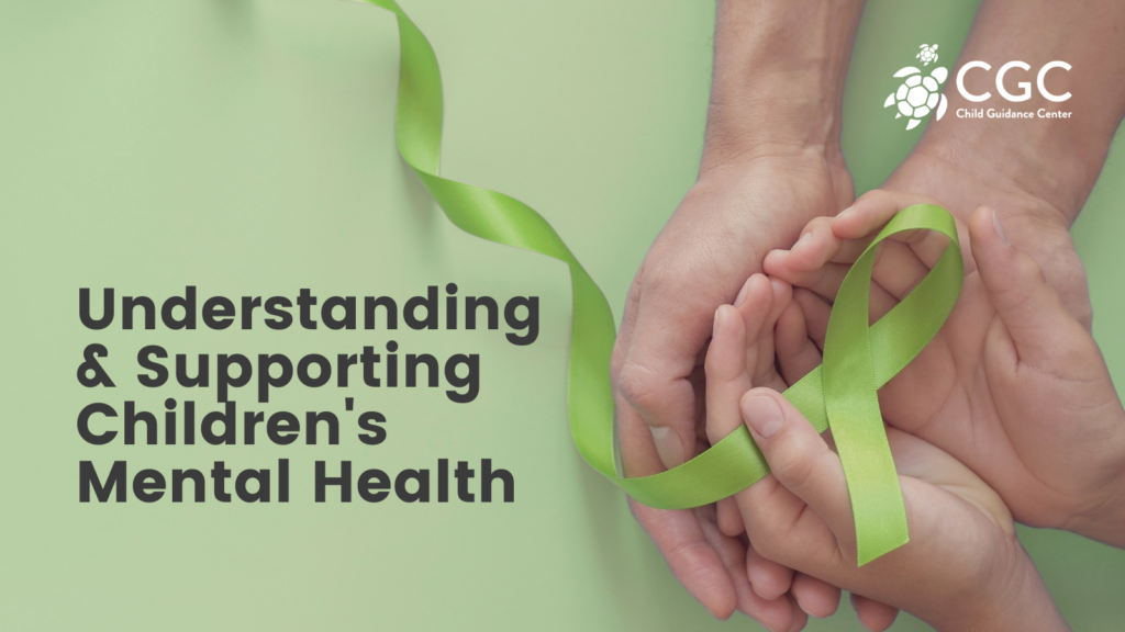 "Understanding the Supporting Children's Mental Health" text overlaid over a photo of an adults hands cupping a child's hands. The child's hands are holding a green ribbon for Mental Health Awareness